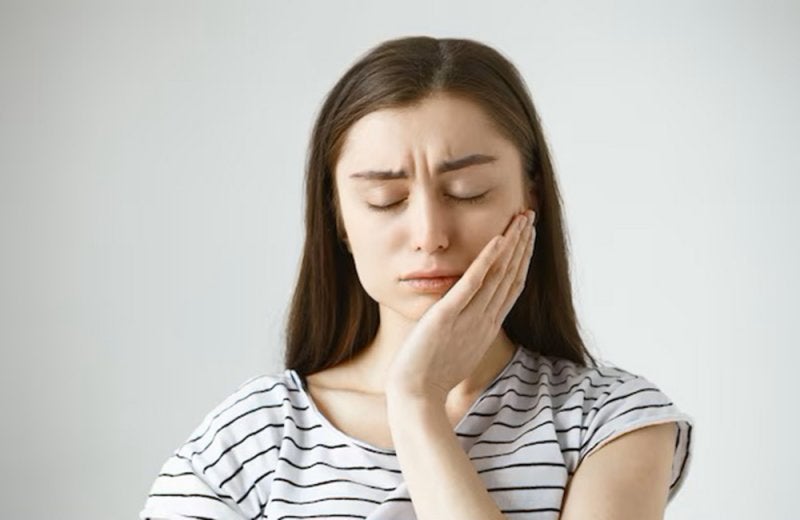 Mujer tomando su cara con dolor